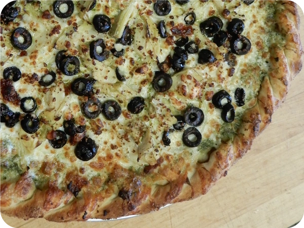 Pizza slice with white sauce and olives